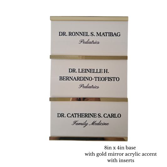 Three personalized pediatric doctor name signs stacked vertically, featuring gold mirror acrylic accent bands. The signs are cream-colored with black printed text and are shown on a white background with a text overlay at the bottom detailing the dimensions and inserts.